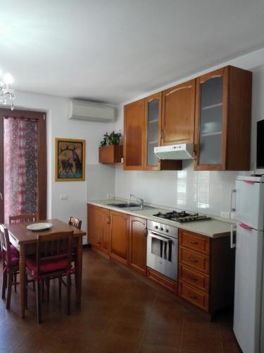 a kitchen with wooden cabinets and a table and a stove at Appartamenti da Ermanno in Bonassola
