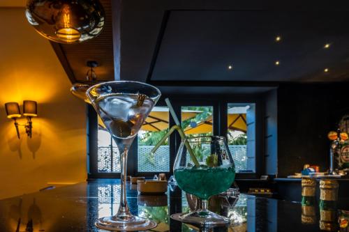two wine glasses sitting on top of a bar at Majestic Hotel in Tunis