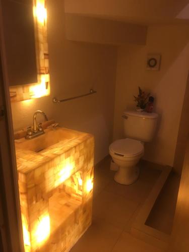 a bathroom with a sink and a toilet with lights at CASA EN EL FRACCIONAMIENTO SAN FERNANDO 1 in Cuautlancingo