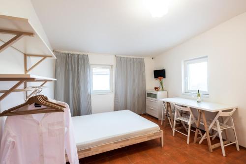 a bedroom with a bed and a desk and a table at Slavia penzion in Mikulov