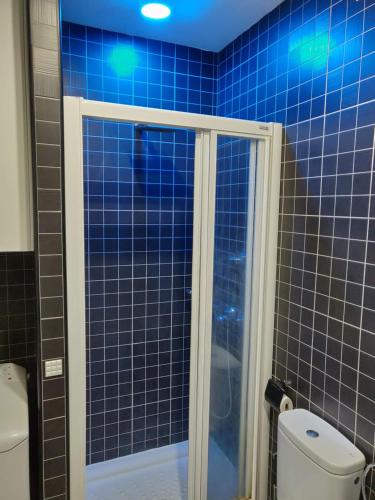 a blue tiled bathroom with a shower and a toilet at Studio Gio - Paraiso del Sur in Playa Paraiso