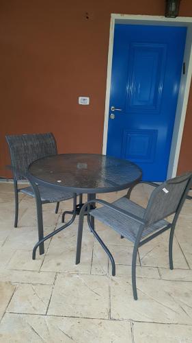 a table and two chairs sitting next to a blue door at zimmer cigale in Odem