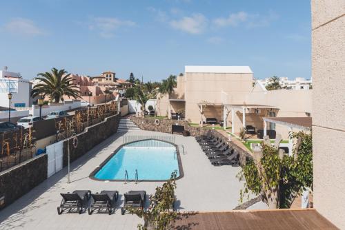 vistas a una piscina con mesas y sillas en La Chalana, en Corralejo