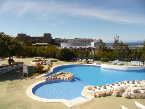a large swimming pool with chairs and umbrellas at Studio Gio - Paraiso del Sur in Playa Paraiso