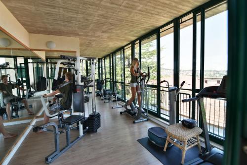 una palestra con attrezzature per il fitness e finestre di Hotel Del Buono Wellness & Medical Spa a Chianciano Terme