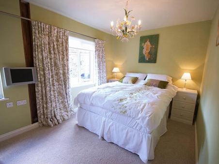 a bedroom with a large white bed and a window at The Hamlet in Cromer