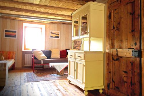 a yellow cabinet in a living room with a couch at Rifugio Serot in Roncegno