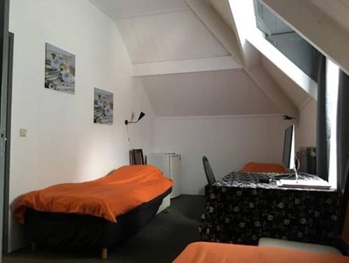 ムールデイクにあるPension Moerdijkのベッド2台とテレビが備わる客室です。