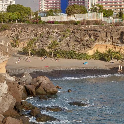 a beach with people on the sand and water at Studio Gio - Paraiso del Sur in Playa Paraiso