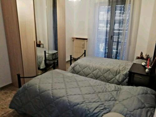 a bedroom with two beds and a desk and a window at A Casa di Raffy in Santeramo in Colle
