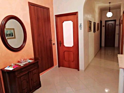 a hallway with a red door and a mirror at A Casa di Raffy in Santeramo in Colle