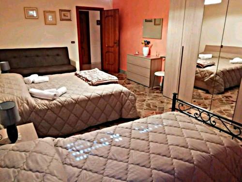 a bedroom with two beds and a mirror at A Casa di Raffy in Santeramo in Colle
