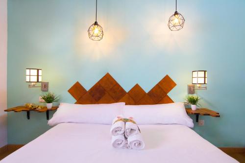 een slaapkamer met een wit bed en slippers bij Catedral Apartments in Valencia