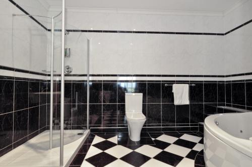 a bathroom with a black and white checkered floor at Broadhaven Bay Hotel in Belmullet