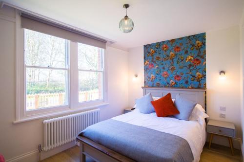 - une chambre avec un lit et un papier peint floral dans l'établissement Longstowe Farmhouse, à Long Stowe