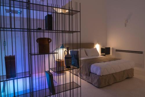 um quarto com uma cama e uma parede de vidro em Donna Domenica Boutique Suites em Polignano a Mare