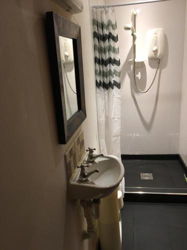 a bathroom with a sink and a mirror and a shower at Campsie View in Drymen