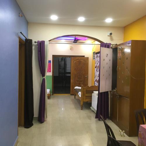 a room with a hallway with purple curtains and a door at Jayaram Residency Tirupathi in Tirupati