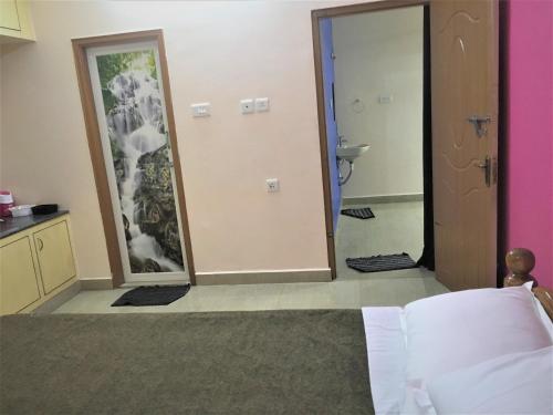 a bedroom with a mirror and a bathroom with a sink at Jayaram Residency Tirupathi in Tirupati