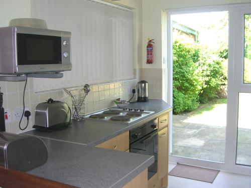 a kitchen with a stove and a tv on the wall at Stavordale House in Weymouth