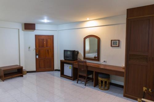 a room with a desk with a television and a mirror at Forum House Hotel Krabi in Krabi town