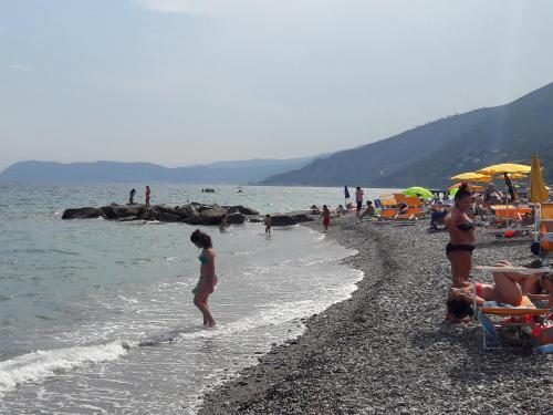 a group of people on the beach at the water at Appartamento vista mare in Albenga