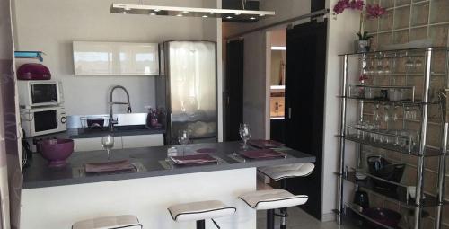 une cuisine avec un bar avec des tabourets et un comptoir dans l'établissement Appartement Naturiste 