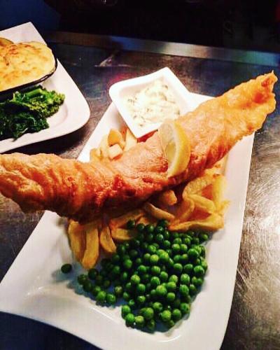 a plate of food with fish and chips and peas at The Tormaukin in Glendevon
