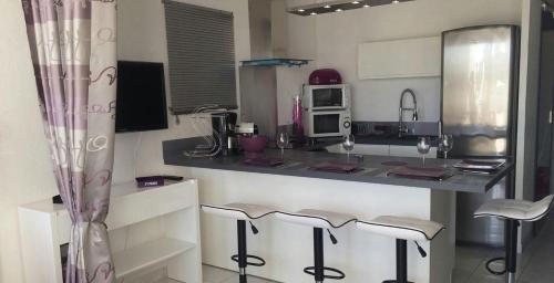 d'une cuisine avec un comptoir et des tabourets de bar. dans l'établissement Appartement Naturiste 