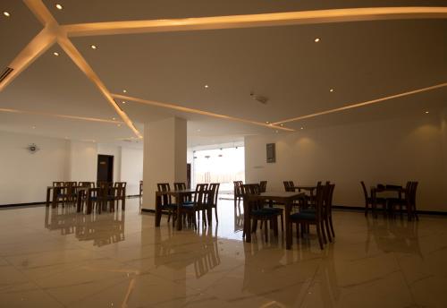 a dining room with wooden tables and chairs at Home Station Hotel in Muscat