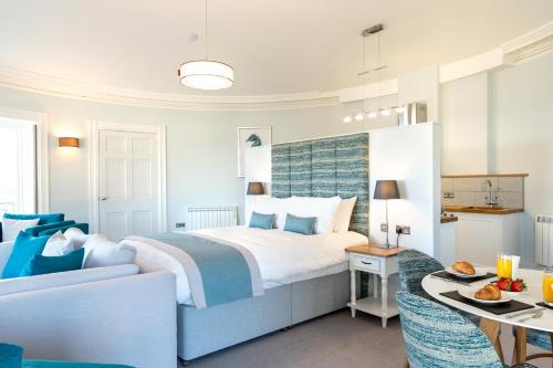 a hotel room with a bed and a table at Sandhills Apartments, Mudeford in Christchurch