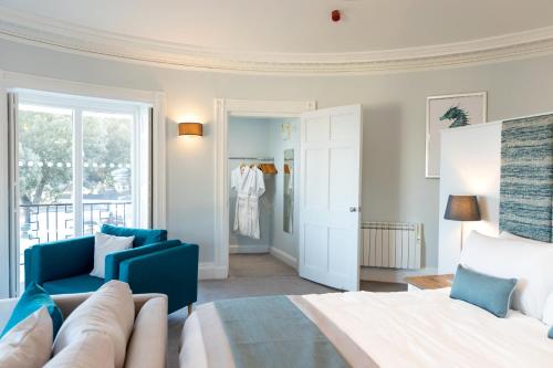 a bedroom with a bed and a blue couch at Sandhills Apartments, Mudeford in Christchurch