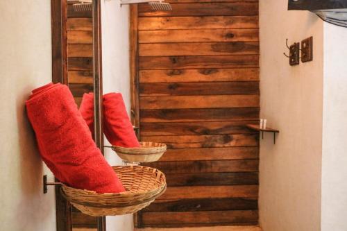 a row of red boots in baskets in a hallway at Namaste Jungle - A Boutique Homestay in Assagao