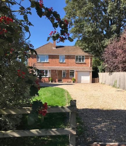 a brick house with a fence in front of it at Barnfield Bed and Breakfast in Downton