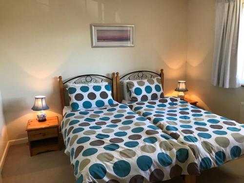 a bedroom with a blue and white bed with two lamps at Barnfield Bed and Breakfast in Downton
