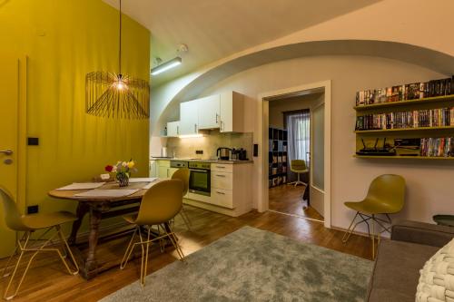 uma cozinha e sala de estar com mesa e cadeiras em Yellow Flat by GrazRentals with best location & free parking em Graz