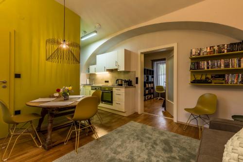 a kitchen and living room with a table and chairs at Yellow Flat by GrazRentals with best location & free parking in Graz