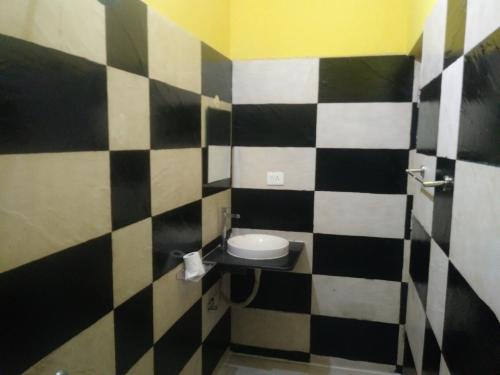 a bathroom with a black and white checkered wall at ROYALE ACHAYA in Chennai