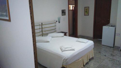 a bedroom with a bed in a mirror at Villa Norma Suites in Vitória