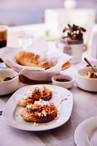a white plate with food on a table at Kalderimi Residencies in Astypalaia Town