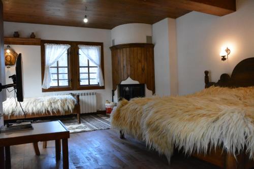 una camera da letto con un grande letto con una grande coperta pelosa di Къща за гости Гайтана a Shiroka Laka