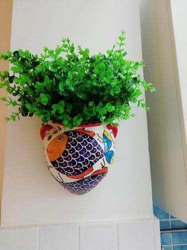 a plant in a vase hanging on a wall at Blue Sea Apartment in Torre Canne