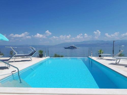 a swimming pool with a cruise ship in the water at Villa R&B in Sutivan