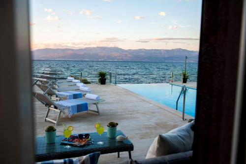 a pool with lounge chairs and a table and the water at Villa R&B in Sutivan