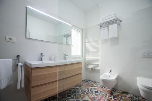 a bathroom with a sink and a toilet and a mirror at Villa R&B in Sutivan