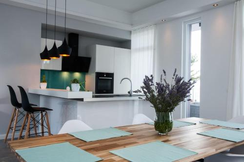 a kitchen with a wooden table with a vase of flowers on it at Villa R&B in Sutivan