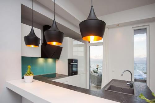 a kitchen with black pendant lights and a sink at Villa R&B in Sutivan