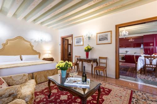 a hotel room with a bed and a living room at Ca' dei Cuori on the Grand Canal in Venice