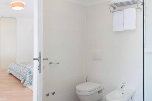 a white bathroom with a toilet and a bed at Villa R&B in Sutivan