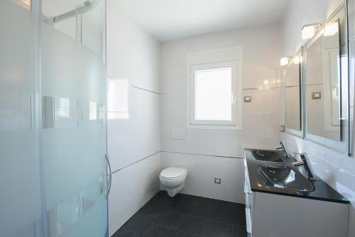 a white bathroom with a sink and a toilet at Villa Roel in Calpe